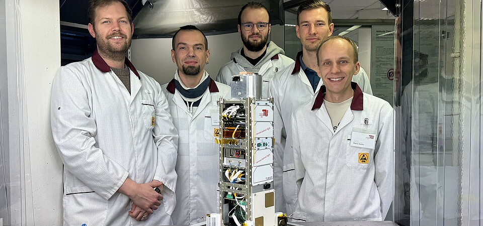 The QUICK³ flight model in the integration laboratory at the Department of Space Technology with the development team from the TU Berlin.